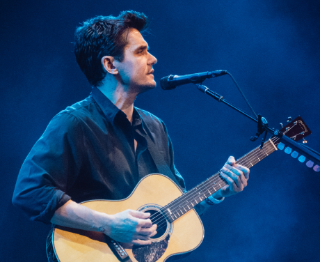 View a photo John Mayer playing an acoustic guitar on stage in Phoenix, Arizona in color.