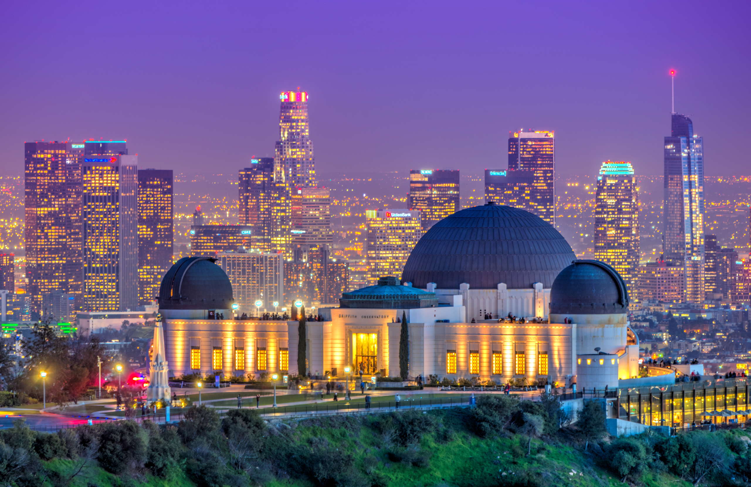 A landscape of the Griffith Observatory with the Los Angeles skyline in the backdrop.